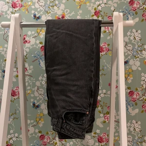 Svarta jeansbyxor - Snygga svarta jeansbyxor med en klassisk straight passform. Perfekta för en avslappnad stil. De har en traditionell femficksdesign och knappgylf. Passar S-XS