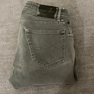 Grå jeans från Jacob Cohen - Tja! Säljer nu dessa snygga gråa jeans Jacob Cohën! De är gråa med en liten grön accent vilket gör det perfekt till dessa våriga dagar! Det är size 32, men har varit sönder längst ner men har fixat det, därför är det så lågt pris! Jag skulle säga att storleken är 28-29 W och 30L. Nypris: 7499kr‼️❌ Mitt pris: 1199kr✅🤝Tveka inte med frågor och pris kan diskuteras!🙌🤝