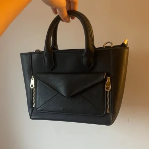 Svart handväska med axelrem - Snygg svart handväska från Don Donna med avtagbar axelrem och två dragkedjor framtill. Aldrig använd och passar till allting💕💕