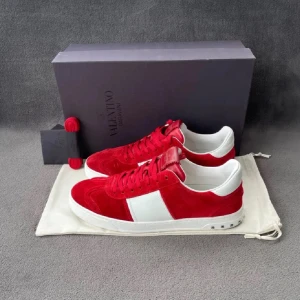 Röda och vita sneakers från Valentino - Snygga röda sneakers från Valentino med vita detaljer. Skorna har en klassisk design med snörning och en bekväm sula. Perfekta för att ge din outfit en färgklick.