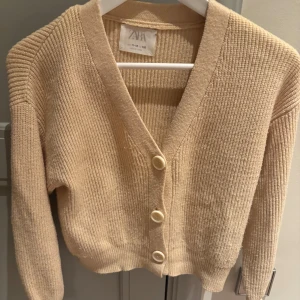 Beige stickad kofta från Zara - Säljer en mysig beige stickad kofta från Zara med knappar framtill. pris kan diskuteras!🩷stor i storleken och passar mig som är s i vuxen storlek!