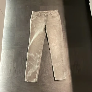 Grå jeans från Jack & Jones - Snygga grå jeans från Jack & Jones i slim fit. De har en klassisk femficksdesign och en knappgylf. Perfekta för en stilren look. Köpt på Jack & Jones. 