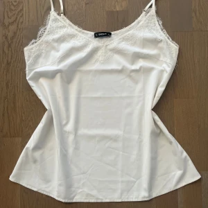 Vit linne med spetsdetaljer  - Fint och stilrent vitt linne med spetsdetaljer. Använt fåtal gånger så är i mycket bra skick