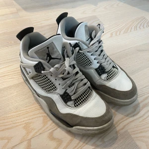Jordan 4s military black  - Jordans i vitt och grått med klassisk design. Skorna har snörning och en ikonisk logga på tungan och sulan. Är i helt okej skick men lite smutsiga. (It äkta) ser däremot äkta ut. 