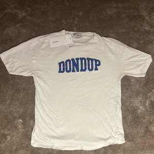 Vit t-shirt från Dondup - Snygg vit t-shirt från Dondup med tryck. Perfekt under en cardigan eller på en sommardag. Nypris - 1399kr. Vårt pris - 399kr. Tag inkluderad.