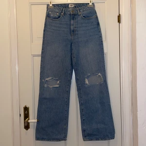  jeans med slitningar - Snygga blå jeans med hög midja och slitningar på knäna. De har en klassisk femficksdesign och raka ben. Perfekta för en avslappnad stil.