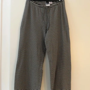 Randiga byxor från Gina Tricot - Snygga svartvita randiga byxor från Gina Tricot i storlek M. Byxorna har en bekväm passform med snörning i midjan.😍😍