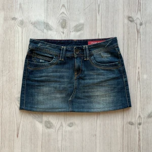 Lågmidjad jeanskjol  - Mörkblå lågmidjad jeanskjol från Cross Jeans som jag har sytt upp från en längre kjol. Fint skick. Kan inte hitta storlek men skulle säga S/M. Tvärs över midjan är det 39 cm. Använd gärna köp nu!