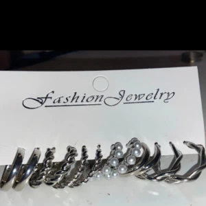 Set med silverfärgade örhängen - Ett set med olika silverfärgade örhängen från Fashion Jewelry. Innehåller både släta och tvinnade ringar samt örhängen med pärldetaljer. Perfekt för att mixa och matcha till olika stilar.