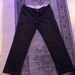 Dickies 873 - Snygga svarta byxor från Dickies med en klassisk design. Byxorna har en rak passform och är tillverkade i ett slitstarkt material. Perfekta för en stilren look. Har klippt upp sömmen där nere för att få en liten flared look 