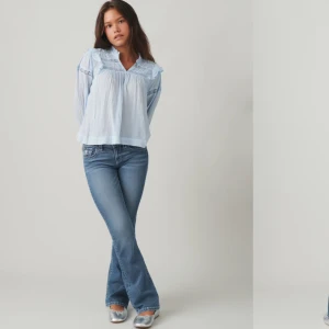  Blå broderade jeans - Snygga blå jeans med broderade detaljer på bakfickorna. De har en bootcut-stil som ger en retro känsla. Perfekta för att ge din outfit en unik touch. Säljer pga att jag inte använder dem! Helt slutsålda, går inte att köpa på hemsidan längre💓 Storlek 158, fåtal gånger använda.