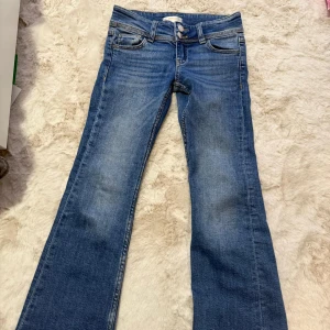 Blå jeans från Gina Tricot - Snygga blå jeans från Gina Tricot i storlek 134. De har en klassisk femficksdesign med knappar och dragkedja framtill. I fint skick.