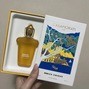 Dolce Amalfi Eau de Parfum från Casamorati - Upptäck Dolce Amalfi Eau de Parfum från Casamorati, en lyxig doft i en elegant flaska. Förpackningen har en färgglad illustration inspirerad av Amalfikusten. Perfekt för den som söker en unik och sofistikerad doftupplevelse. Uppskatta mängden genom att kika på bilderna☺️✨ kom tyvärr sådär vid beställning kan skicka bildbevis. Köpt för ca 1000kr