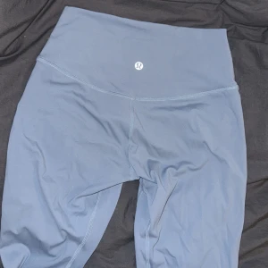 Blå leggings från Lululemon - Väldigt sköna blå leggings från Lululemon som ger en snygg kroppsform. Tillverkade i ett mjukt och stretchigt material som ger en bekväm passform. Storlek 6 (36-38)