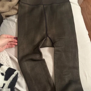 Svarta leggings med fleecefoder - Mysiga svarta leggings med mjukt fleecefoder på insidan. Perfekta för kalla dagar när du vill hålla dig varm och bekväm. De har en tight passform och är tillverkade i ett stretchigt material som ger bra rörelsefrihet. Storlek S-M 