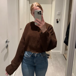 Brun stickad croppad tröja - Säljer en brun stickad tröja med croppad passform. Tröjan har långa stora ärmar. 150 kr eller kom med bud!