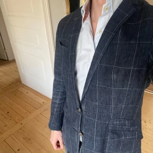 Blå rutig linne kavaj från Tiger of Sweden - Riktigt snygg blå kavaj med rutigt mönster från Tiger of Sweden. 100% linne. Storlek 48. Riktigt fint skick