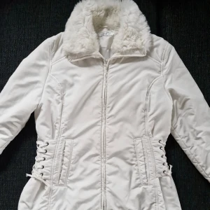 Vintagejacka med snörning - Fantastisk vintagejacka från Agenda 🎀 Med pälskrage- och muddar, samt korsettliknande snörning på sidorna! Snörena kan dras åt lite för tajtare/ lösare passform. Finns även två fickor på framsidorna. Stängs med dragkedja framtill. Storlek 14 (XL) på lappen, passar mer som en L enligt mig. Finns några minimala bruksspår/ märken, bilder på dessa kan skickas. I övrigt är jackan i fint skick!