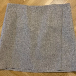 Beige kjol från COS - Beige ullkjol från COS i en stilren design.