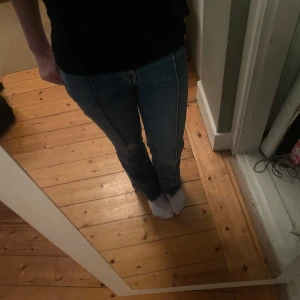 Blå bootcut jeans från Lindex - Snygga blå bootcut jeans från Lindex med klassisk femficksdesign. De har en bekväm passform och är perfekta för en avslappnad stil. Jeansen har en dragkedja och knapp framtill.