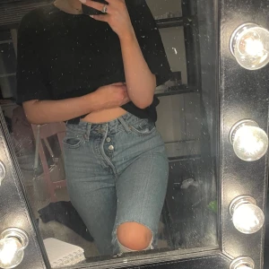 Blå jeans med slitna knän - Blå jeans med knappar istället för blixtlås med hål i högra knät, säljes då det inte längre faller mig i smaken💕