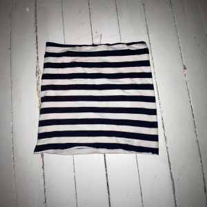 Randig kjol - Snygg kortkjol med svart och vit randigt mönster. Perfekt för en solig dag på stranden, du matchar till och med färger med skrattmåsarna💪. Kjolen har en enkel design utan extra detaljer, vilket gör den lätt att matcha med mer unika toppar, om det är det du dras till.🥋