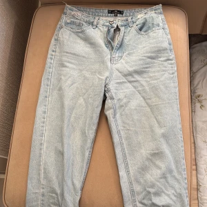 Ljusblå högmidjade jeans - Snygga ljusblå högmidjade jeans från Riot, köpta på Nelly. De har en avslappnad passform och slitna detaljer vid fållen.