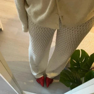 Vita stickade byxor från ZARA - Snygga vita stickade byxor från ZARA med ett unikt hålmönster. Byxorna har en bekväm passform och är perfekta för en avslappnad stil. 