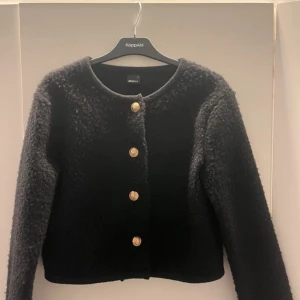 Svart jacka från Gina Tricot - Snygg svart jacka/ kofta från Gina Tricot med guldknappar. Den har en rund halsringning och är långärmad. Perfekt för att ge en elegant touch till din outfit. Kan gå ner i pris vid snabb affär❤️