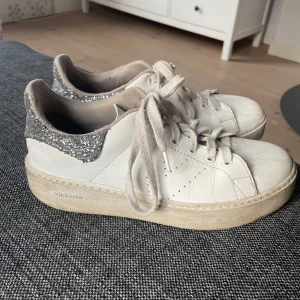 Sneakers - Skor liknande Veja!! Snygga vita sneakers från Victoria med glittriga detaljer på hälen. Skorna har snörning och en klassisk design som passar perfekt till vardags. De passar skostorlekar från 36-38 skulle jag säga! 🤗💕