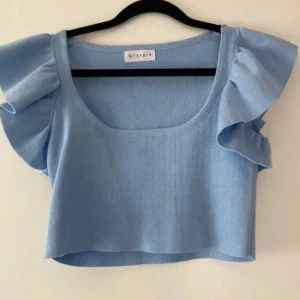 Ljusblå croppad topp från Giorgia - En topp från märket Giorgia. Den är i ett stretchigt material vilket gör att den passar strl XS-S. Tillhör egentligen ett sätt med kjol se annat inlägg ( kan sälja båda för ett bättre pris)