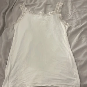 Vit linne - Ett as skönt linne från Thailand. Den känns som ”soft touch”. Den är väldigt stretchig. Den har inget märke eller storlek men sitter som S men eftersom den är stretchig kan den passa som en större storlek också.