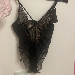 Body Hunkemöller helt ny, prislapp kvar - Helt helt ny med prislapp kvar (se sista bild) så självklart aldrig använd. Strl XS Väldigt mörk mörk blå med guldiga/champange spets Från Hunkemöller