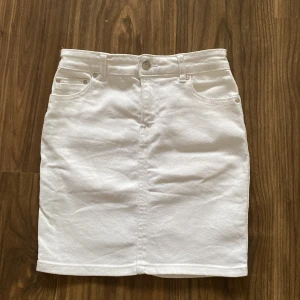 Vit jeans kjol - Den är vit jeans kjol, den är i bra form. Kjolen är lite lång. Kjolen är i storlek 34.  Använd inte en torktumlare för tork.