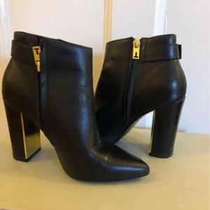 Stövletter skinn  - Svarta stövletter i skinn med fina gulddetaljer. Märke: Ted Baker. Sparsamt använda. Storlek 36.  Nypris 1800