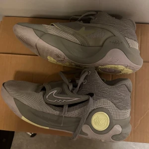 Grå Nike sneakers i storlek herr 46 - Säljer ett par grå Nike sneakers i storlek herr 46. Skorna har en modern design med snörning och en bekväm passform. Perfekta för träning eller vardagsbruk. De är i bra skick och redo för nya äventyr!