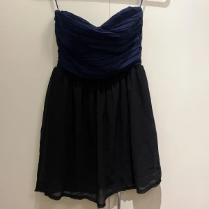 Klänning - Kort klänning utan ärmar med marinblå överdel och svart nederdel, dragkedja på baksidan och gummikant över brösten för att inte glida ner☺️