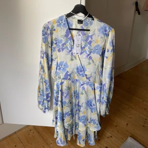 Klänning Gina Tricot  - Superfin klänning som tyvärr inte kommer till användning. Helt oanvänd, prislapp kvar  Slutsåld på hemsidan Glansigt, mjukt material Ballongärmar och knyte i midjan  Nypris 499,95kr