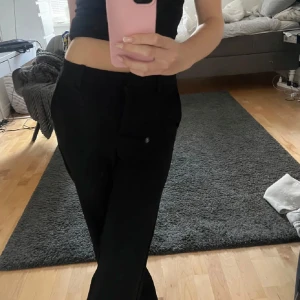 Svarta byxor - Säljer ett par svarta byxor i normal passform. De är Lågmidjade och har en klassisk stil. Byxorna har en liten slitage på ena sidan, men det påverkar inte användningen.  Pris kan diskuteras💞