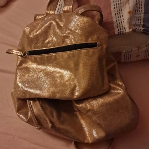 Glittrig Väska - Säljer en super snygg väska i färgen guld! Jag vet inte vart den kommer ifrån