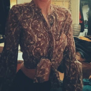 Snygg retro blus i 70-tals stil - Snygg och ledig 70-tals skjorta i retro tyg. Låt din inre hipe komma fram i denna klassiska vintage mönster. 