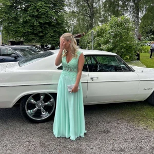 Mintgrön balklänning - Elegant mintgrön långklänning med spetsdetaljer och v-ringad urringning. Klänningen har ärmlös design. Jag hade klänningen på balen och fick många komplimanger om klänningen och den fina färgen som sticker ut i mängden💕 Som referens är jag ca 170