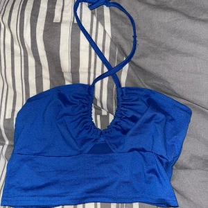 Blå halterneck topp - blå halterneck topp med korsade band. Fick den av en kompis så hon inte ville ha den, hon trodde den va ifrån shein. Storlek 34-36