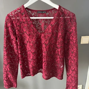 Vinröd spetsblus från Stockh LM - Snygg vinröd spetsblus från Stockh LM med v-ringning.