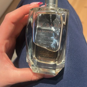 Elie Saab Le Parfum Eau de Toilette - Säljer en elegant Elie Saab Le Parfum Eau de Toilette. Flaskan är stilrent designad i glas med en gyllene vätska inuti. Perfekt för den som älskar en sofistikerad och feminin doft. 