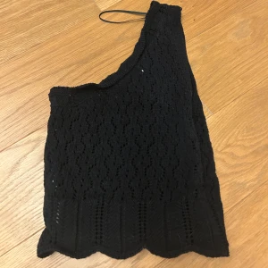 Svart oneshoulder topp från Zara - Snygg svart oneshoulder topp från Zara i ett vackert spetsmönster. Storlek xs och aldrig använd. 🥰💕