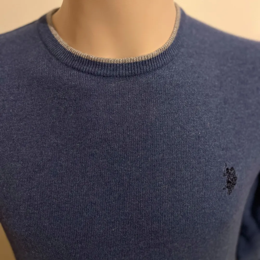 Säljer en stilren blå tröja från U.S. Polo Assn. med rund hals och broderad logga på bröstet. Tröjan har långa ärmar och en slim fit passform, perfekt för en snygg och bekväm look.. Neuletakit & Villapaidat.