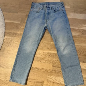 Ljusblå jeans från Levi's 501 - Säljer ett par klassiska ljusblå Levi's 501 jeans. De har en rak passform och är tillverkade i slitstarkt denim. 
