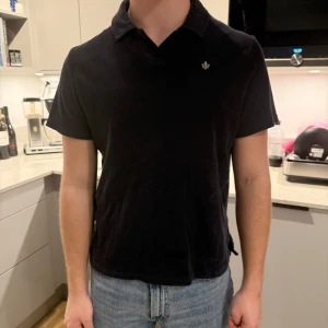 Svart pikétröja frotté från Morris - Snygg svart pikétröja från Morris. Tröjan har korta ärmar och en klassisk krage. Perfekt för en stilren look. Nypris: 999kr