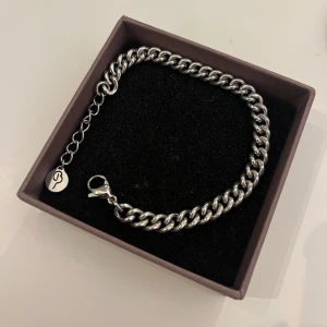 Silverfärgat armband med kedjedesign från Edblad.  - Jag säljer det här snygga silverfärgade armbandet med en klassisk kedjedesign. Armbandet har en justerbar längd.  Perfekt för att ge en stilren touch till din outfit. Endast använd ett fåtal gånger. 